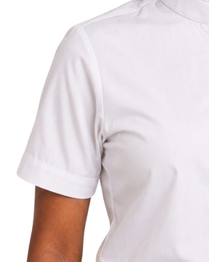 Close-up of a women wearing a white short-sleeve clerical shirt, showing the shoulder, sleeve cuff, and upper torso against a plain white background.