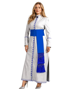 A woman modeling a long white or silver-gray traditional cassock with a bold royal blue sash and matching blue fringe, photographed against a plain white studio background.