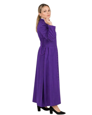 Woman wearing a long purple cassock with a white collar on a white background.
