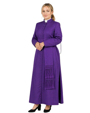 Woman wearing a long purple cassock with a white collar on a white background.