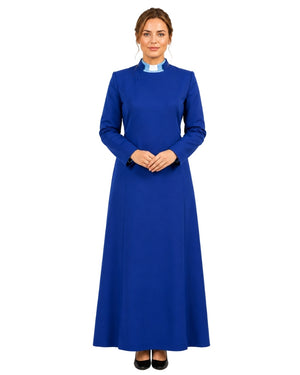 A woman modeling a long-sleeved royal blue cassock with a mock neck and black pointed shoes, standing against a plain white background.