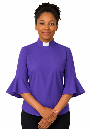 Woman wearing a purple shirt with ruffled sleeves on a white background