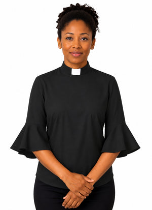 Woman wearing a black shirt with ruffled sleeves on a white background