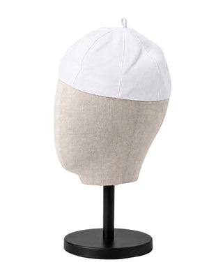 A clergy zucchetto cap with a white top panel and a light beige textured lower section, displayed on a black mannequin head stand against a white background.