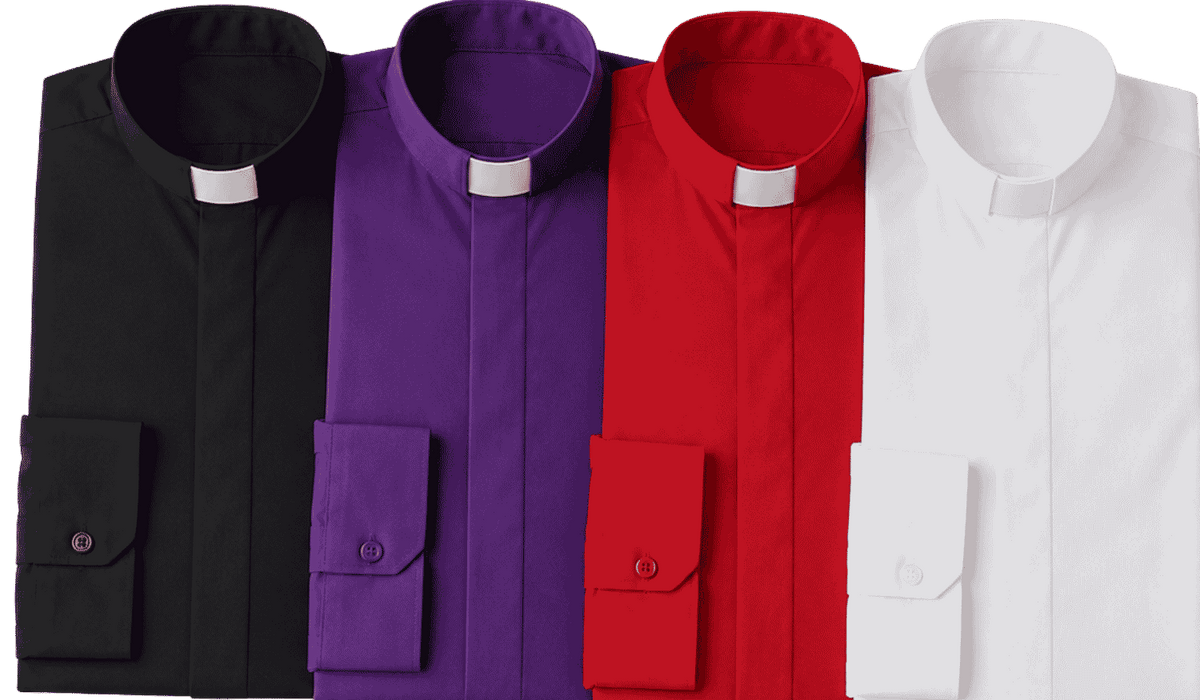 Close-up of a bishop wearing a purple clergy shirt with a white tab collar, standing inside a softly lit church with blurred stone arches and warm ambient light in the background.