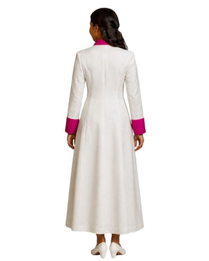 A woman viewed from the back wearing a long white cassock with bright pink contrast trim at the collar and cuffs, standing against a plain white background.