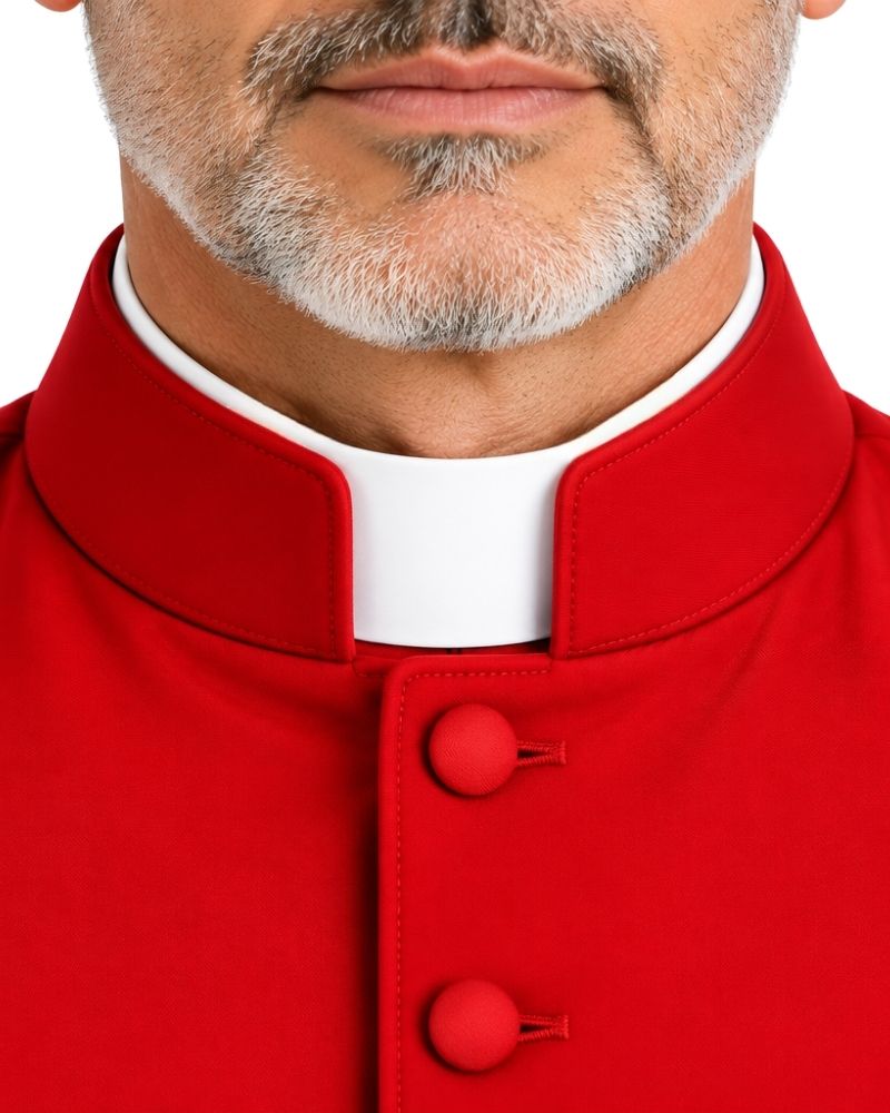 Close-up of a man wearing a Advik Red Clergy Cassock with a white collar insert and red buttons, cropped from the lower face to the chest on a white background.