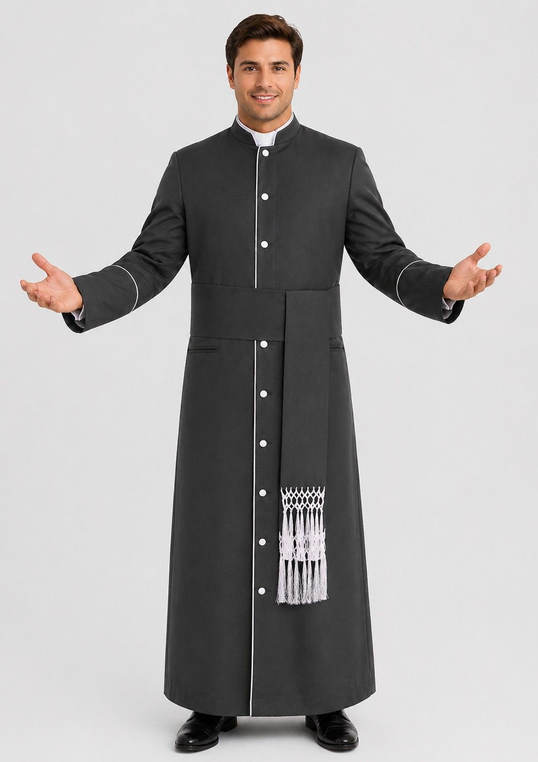 Man wearing a black cassock with white trim on a plain background