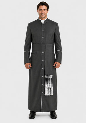 Man wearing a long black robe with white buttons and trim on a plain background