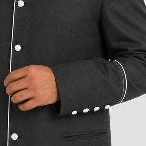 Close-up of a cassock with white buttons on a plain background