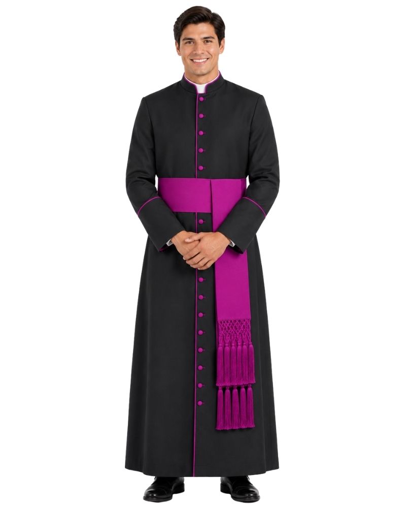 A man modeling a black long-sleeve clerical robe with a bright magenta-purple sash and matching trim, standing against a plain white background.