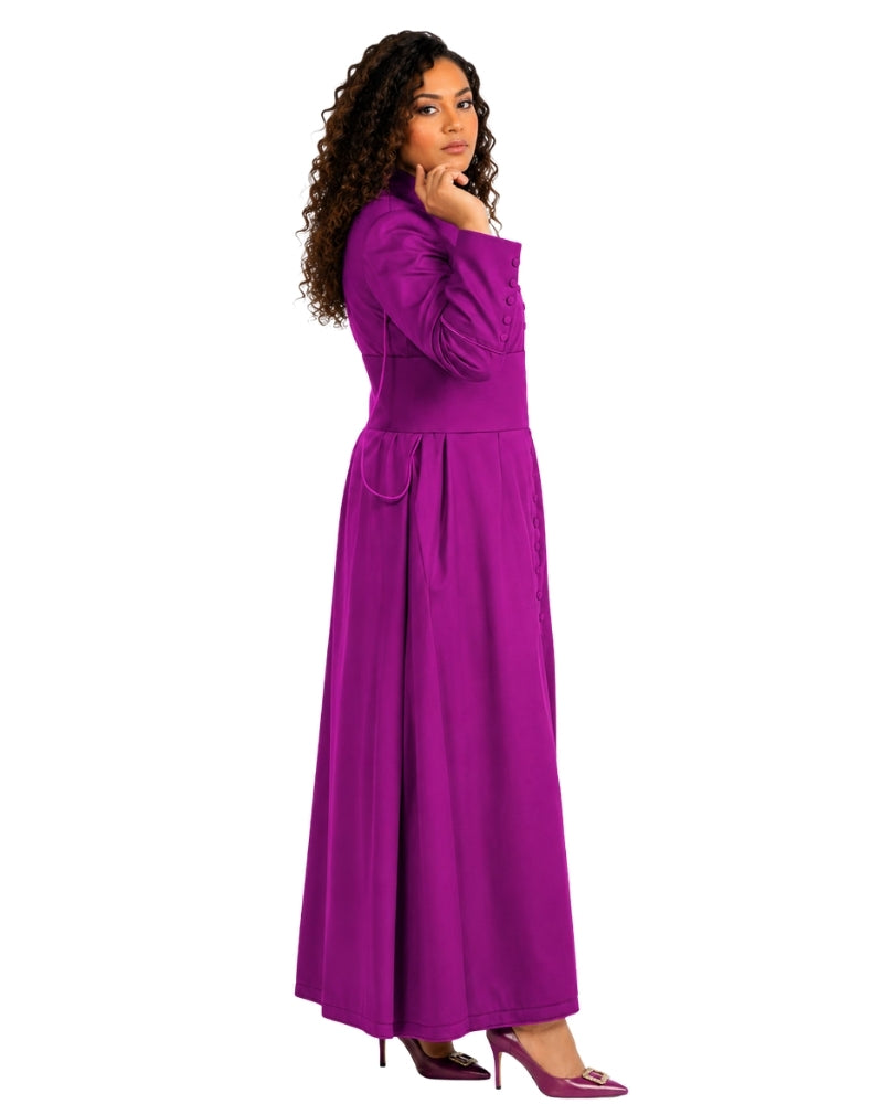 A woman modeling a long magenta-purple cassock with long sleeves, a defined waist, and a flowing skirt, shown against a plain white background.