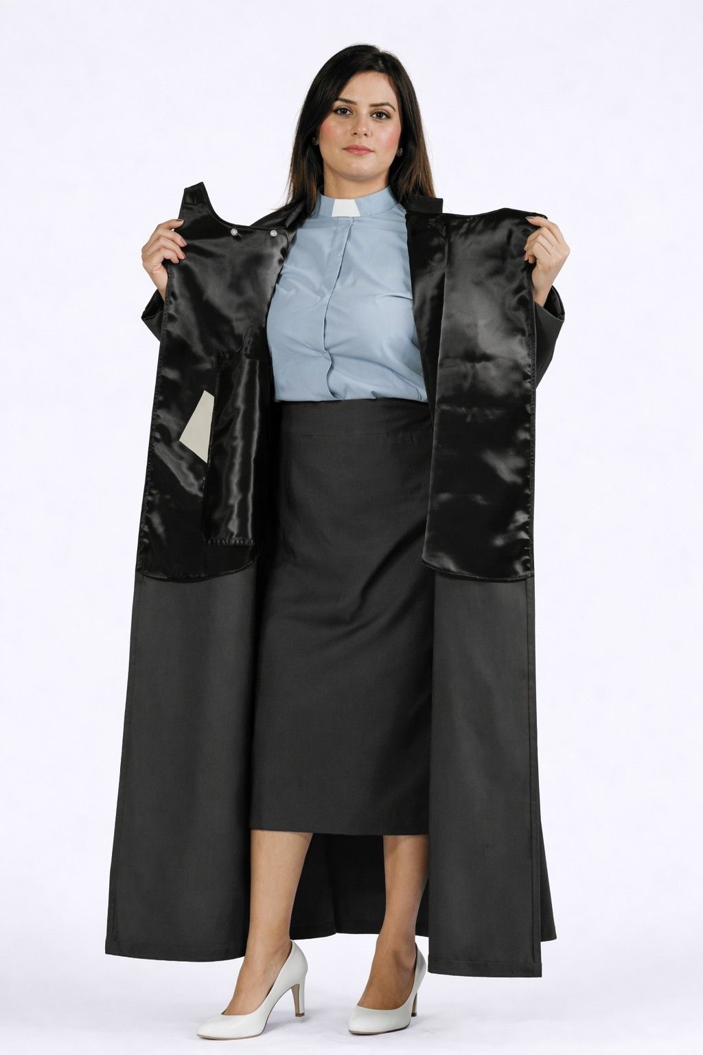 Woman holding a black satin robe over her shoulders against a white background