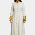 Woman wearing a long white robe with gold accents on a white background