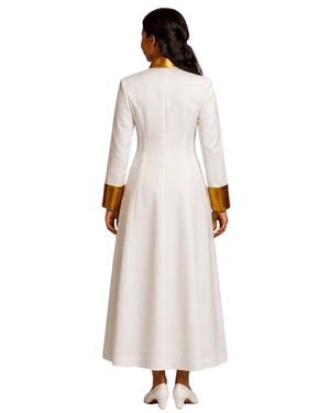 A woman viewed from the back wearing a long white cassock with metallic gold trim at the collar and cuffs, against a plain white background.