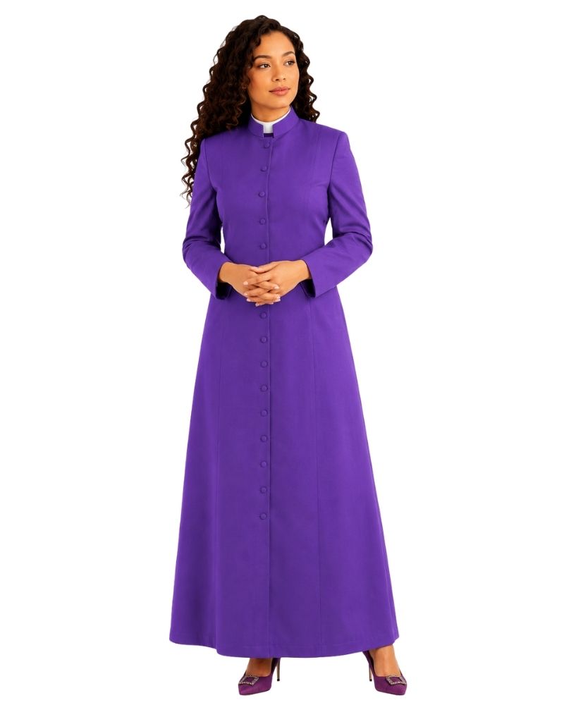 A woman modeling a long-sleeved purple clerical cassock with a high collar and front button closure, paired with purple shoes, against a plain white background.