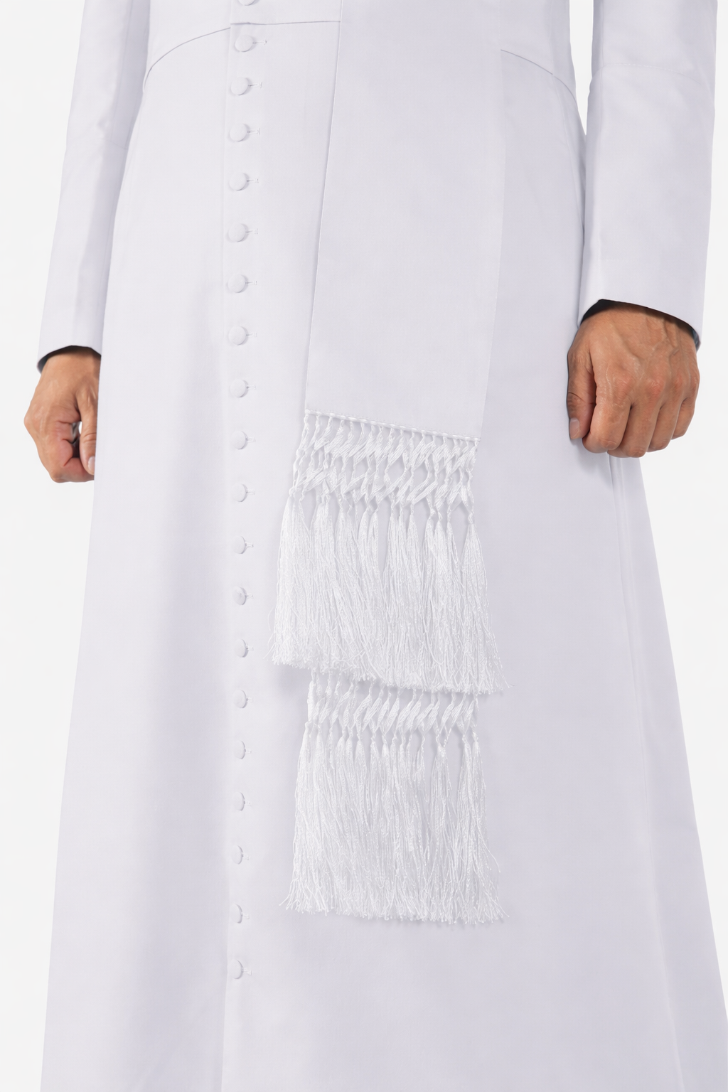 White dress with smocked waist and fringe details on a white background