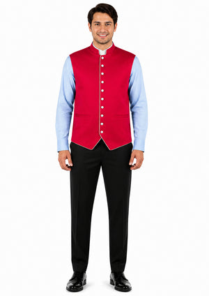 Man wearing a red vest over a light blue shirt with black pants on a white background
