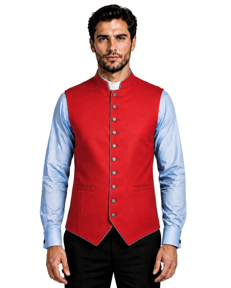 A man wearing a bright red waistcoat vest over a light blue dress shirt and black trousers, photographed against a plain white background.