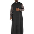 A man modeling a long black clerical robe over a gray long-sleeve shirt and white collar, standing against a plain white background.