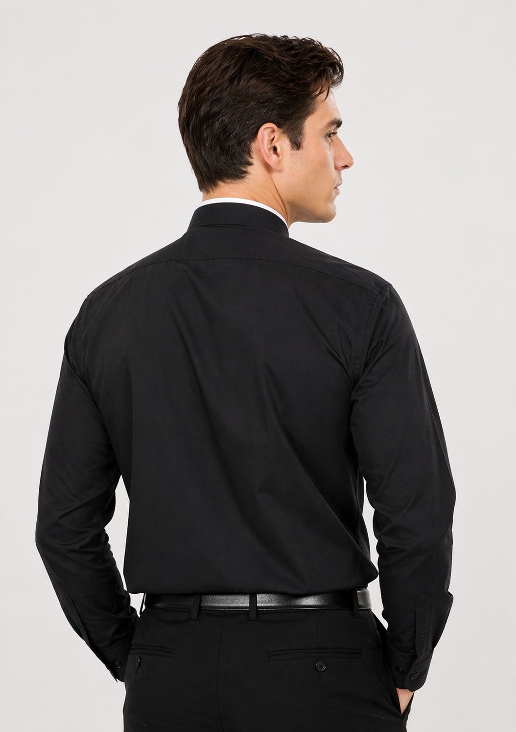 Man wearing a black dress shirt and pants on a white background