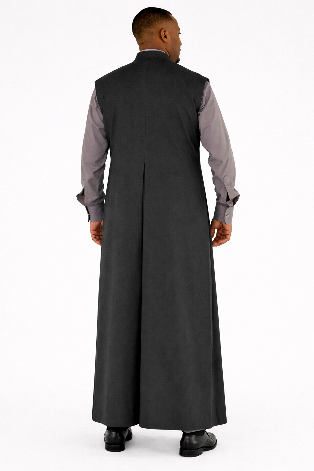 Man wearing a long dark gray robe over a light gray shirt on a white background