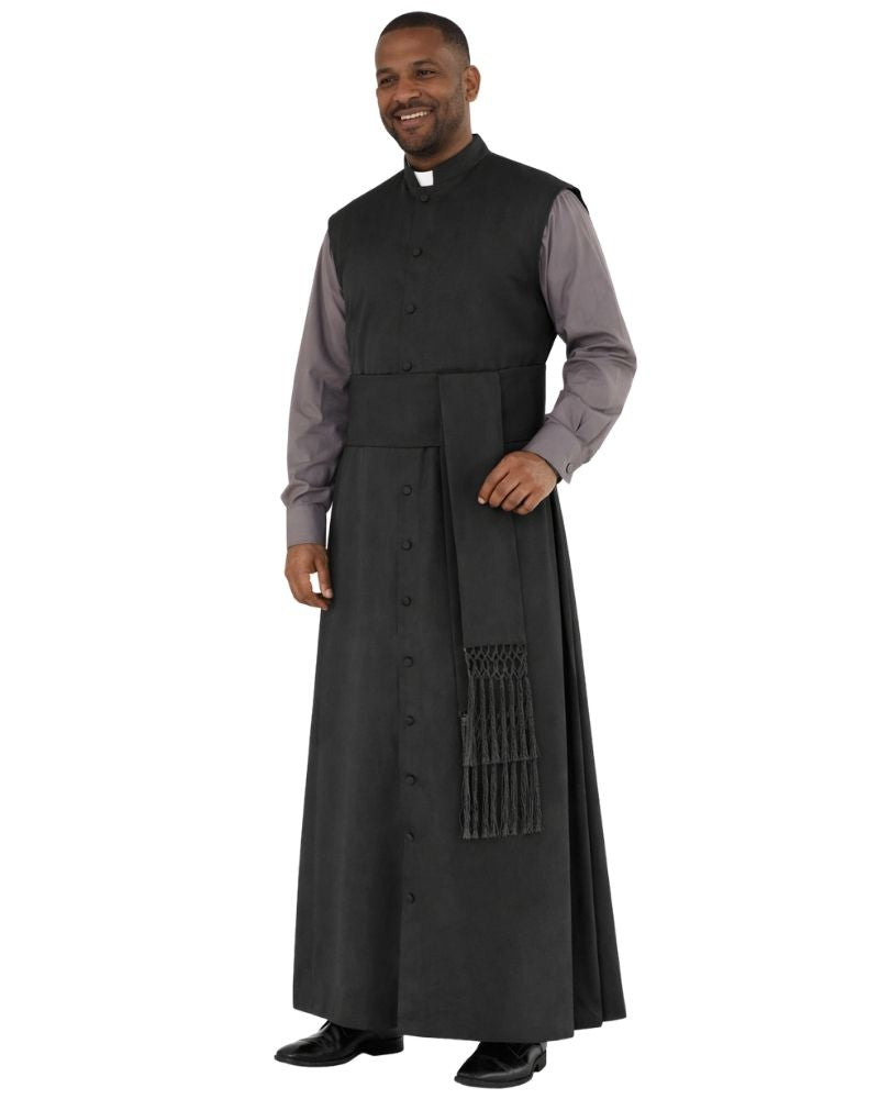 A man modeling a black priestly vestment set consisting of a long black surplice robe with a decorative tassel detail and a matching black button-front vest over a gray long-sleeve shirt, on a plain white background.