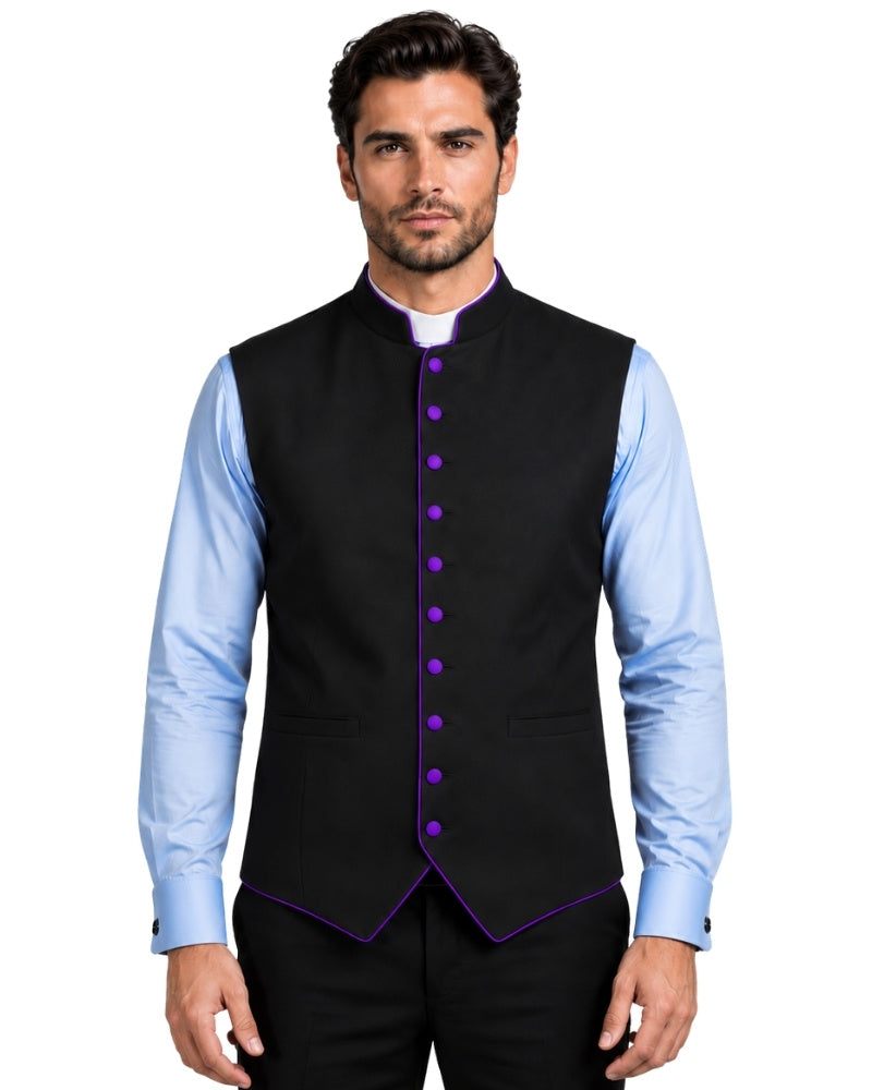 A man wearing a black waistcoat with purple trim and purple buttons, layered over a light blue dress shirt and black trousers, against a  white background.