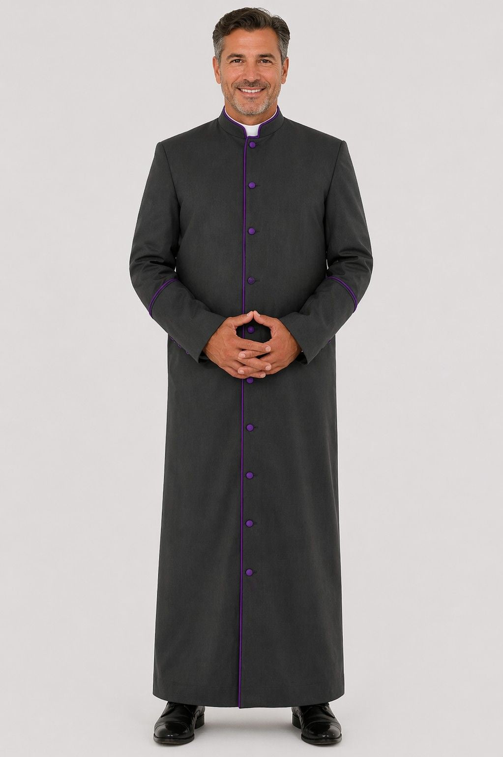 Man wearing a long dark gray robe with purple accents on a light gray background
