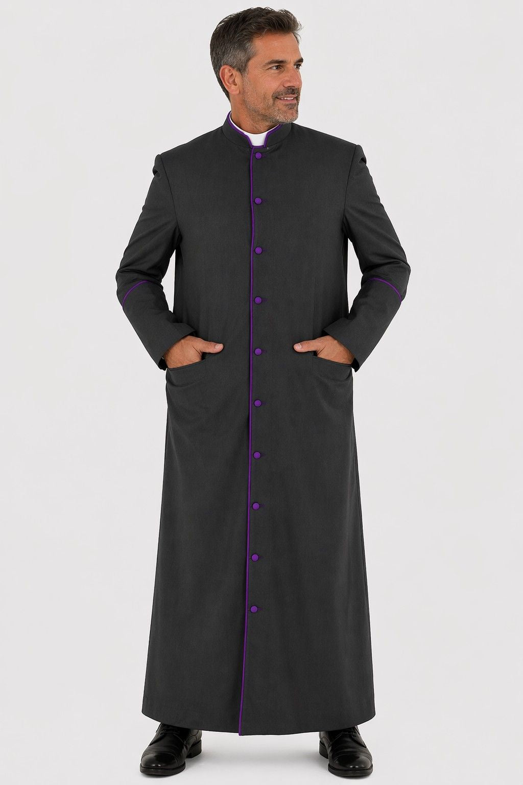 Man wearing a long black coat with purple buttons on a white background