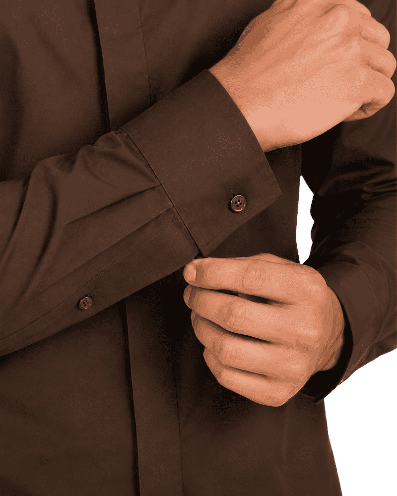 Close-up of a person wearing a dark brown long-sleeve clerical shirt, adjusting the cuff with one hand while the other hand rests near the pocket.