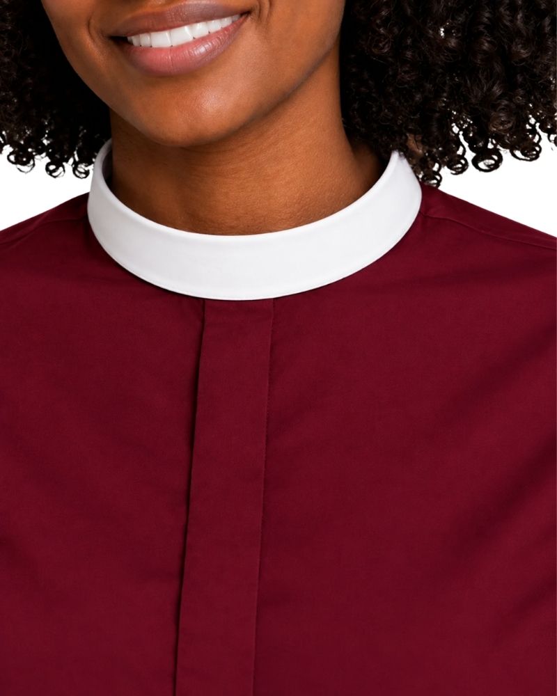 Close-up of a woman wearing a burgundy clerical shirt with a white collar, showing the neck, lower face, and upper chest against a white background.