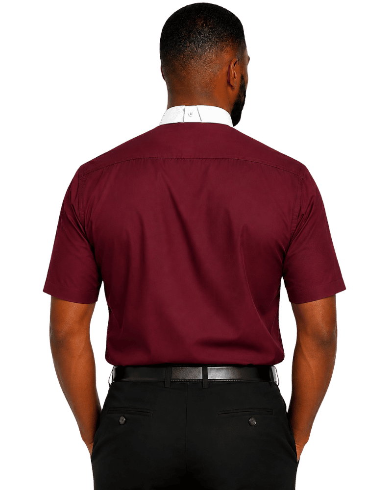 A man viewed from the back wearing a burgundy short-sleeve clerical shirt with a white collar, paired with black trousers and a black belt, against a plain white background.