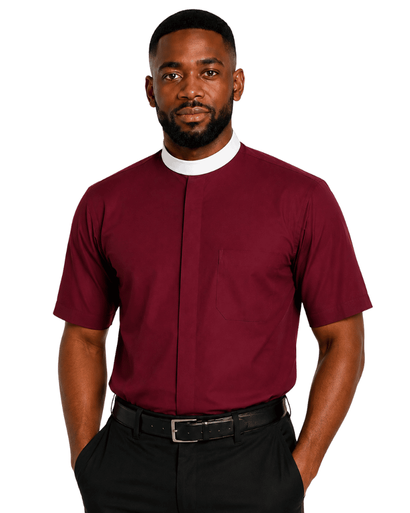 A man wearing a burgundy short-sleeve clerical shirt with a white collar, paired with black trousers and a black belt, photographed against a solid white background.