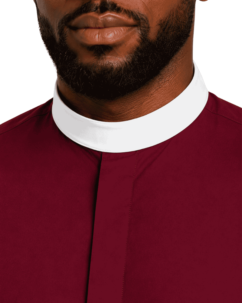 Close-up of a man wearing a burgundy clerical shirt with a contrasting white collar, showing the neck, beard, and lower face against a plain white background.