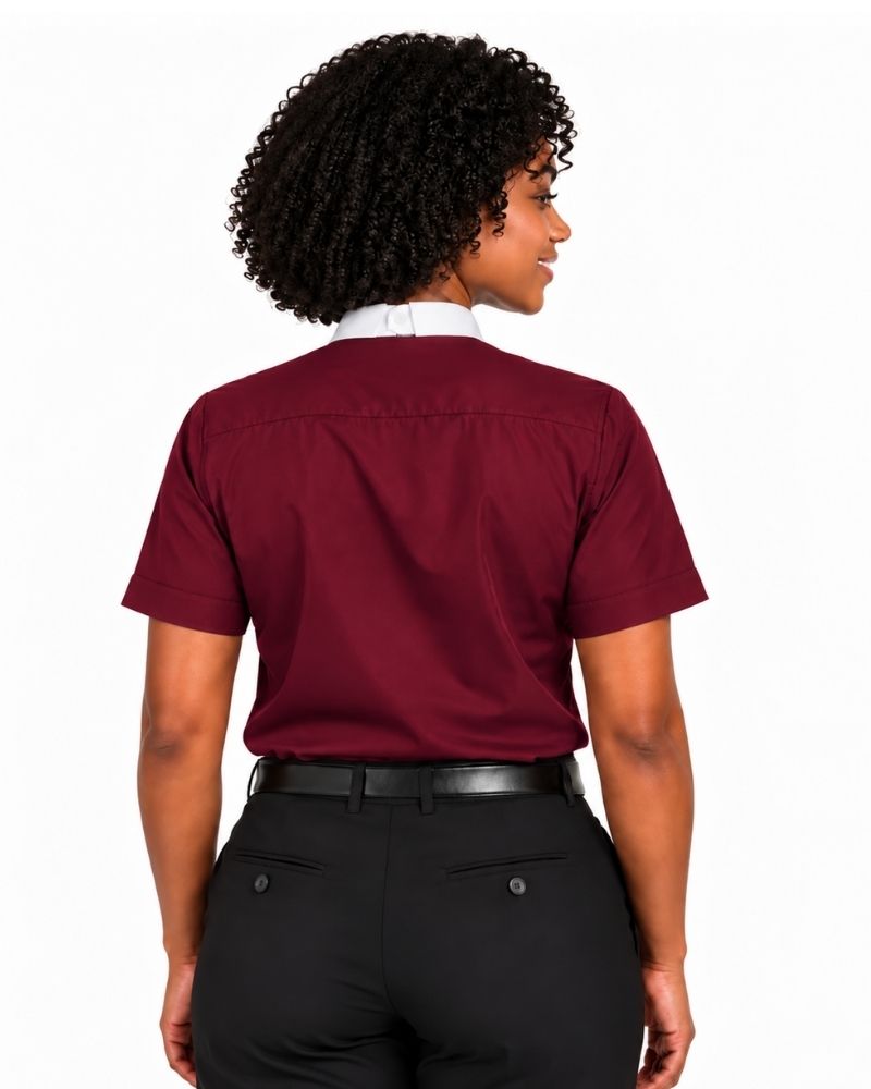 A woman shown from the back wearing a short-sleeve burgundy clerical shirt tucked into black trousers with a black belt, against a plain white background.
