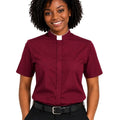 A woman wearing a burgundy short-sleeve clerical shirt with a white collar, paired with black trousers and a black belt, shown against a plain white background.