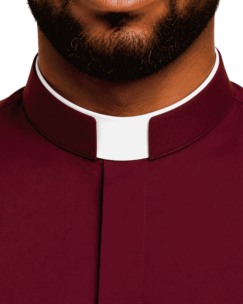 Close-up of a man wearing a burgundy clerical collar shirt with a white clerical collar, showing the neck, beard, and upper chest against a plain white background.