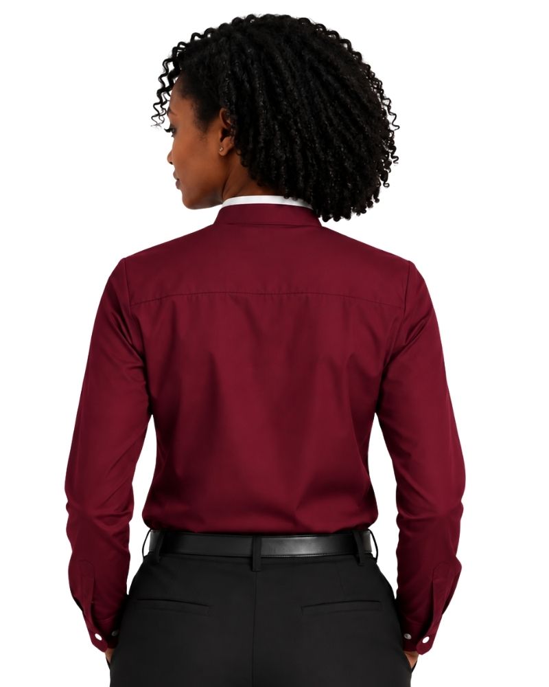 A woman shown from the back wearing a long-sleeve burgundy clerical shirt tucked into black pants with a black belt, against a plain white background.