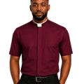 A man wearing a burgundy short-sleeve clerical shirt with a white collar, paired with black trousers and a black belt, standing against a solid white background.