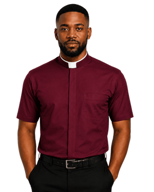 A man wearing a burgundy short-sleeve clerical shirt with a white collar, paired with black trousers and a black belt, standing against a solid white background.