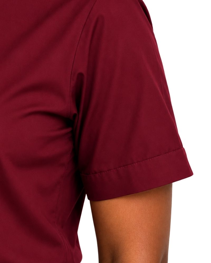 Close-up of a woman wearing a short-sleeve clerical shirt in deep burgundy with a white collar trim, shown against a plain white background.