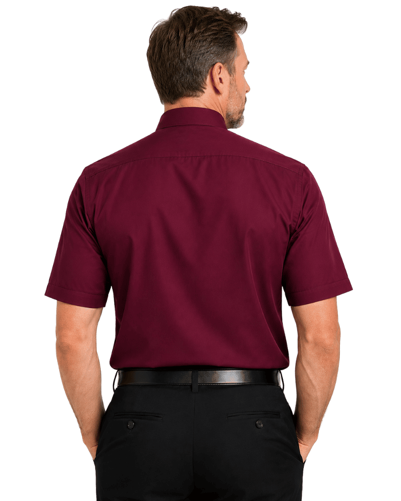 A man viewed from the back wearing a short-sleeve burgundy clerical shirt and black trousers, isolated on a white background.