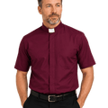 A man wearing a burgundy short-sleeve clerical shirt with a white collar tab, paired with black trousers and a black belt, photographed against a plain white background.