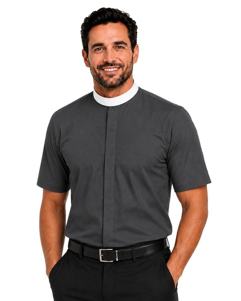 A smiling man wearing a dark gray short-sleeve clerical shirt with a white collar, paired with black trousers and a black belt, against a plain white background.