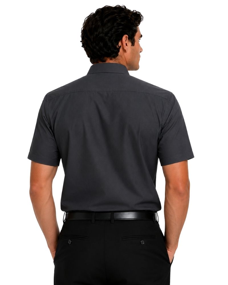 A man viewed from the back wearing a dark charcoal gray short-sleeve button-down clerical shirt and black trousers, set against a plain white background.
