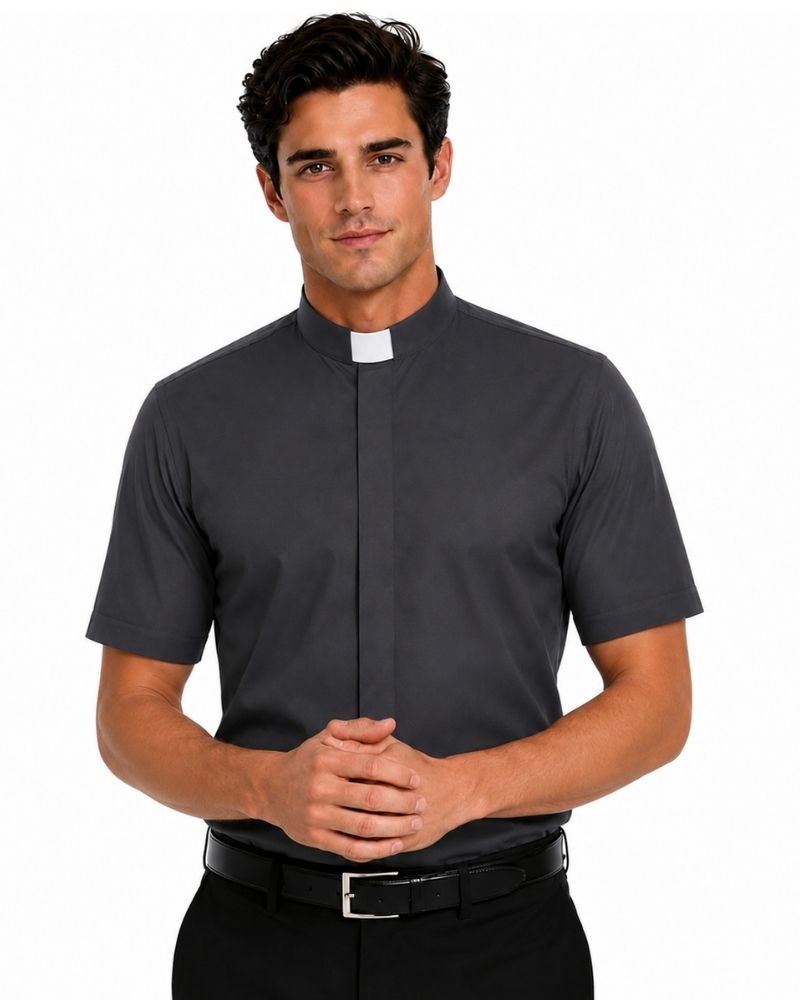 A man wearing a dark gray short-sleeve clerical shirt with a white collar tab, paired with black trousers and a black belt, against a plain white background.