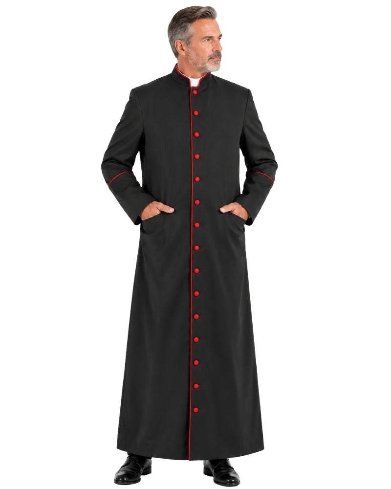 A man modeling a Classic Black Clergy Cassock with Red Trim with red trim and red front buttons, standing against a plain white background.