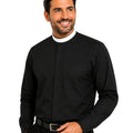 Man wearing a black long-sleeve clerical shirt with a white collar against a light gray background