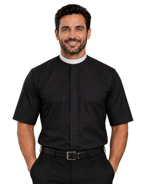 A smiling man wearing a black short-sleeve clerical shirt with a white collar, paired with black trousers and a black belt, against a plain white background.